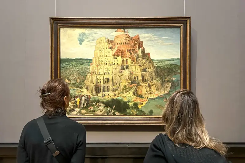 Dwie osoby oglądają obraz Wieża Babel w Muzeum Historii Sztuki w Wiedniu.