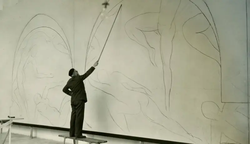 Henri Matisse, z laską w dłoni, kieruje pracami nad szkicem swojego słynnego "Tańca".